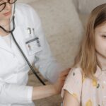 A doctor conducts a health checkup for a young girl at home, ensuring comfort and care.